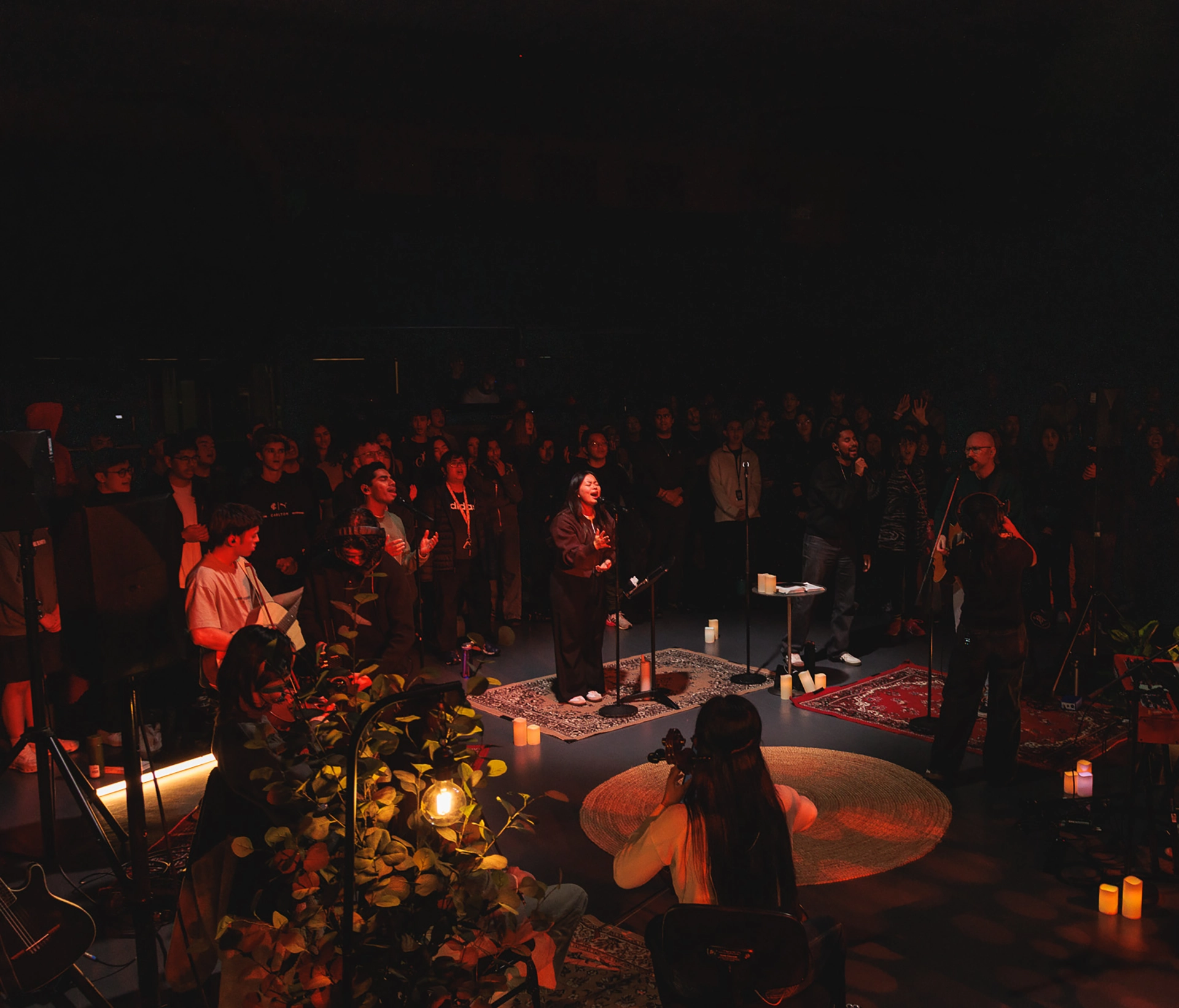 Young adults singing on stage during a worship night
